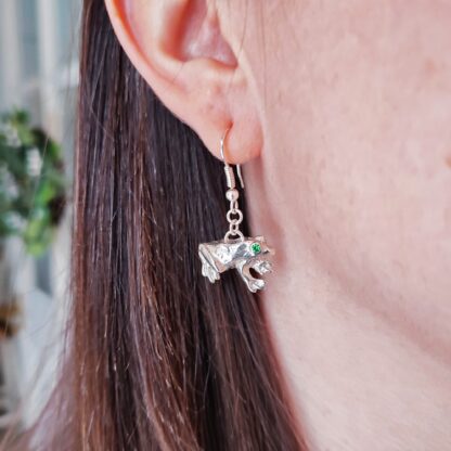 Silver frog earrings worn on the ear