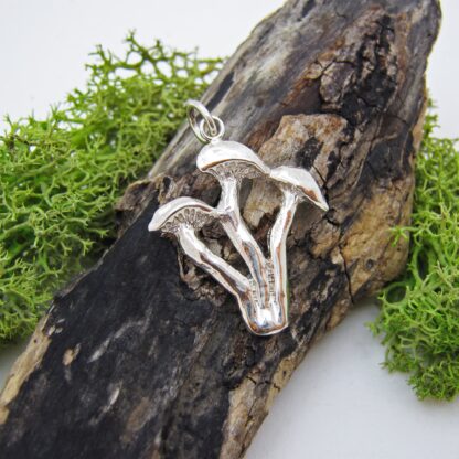 Silver triple mushroom pendant presented on a log